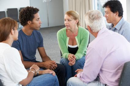 A support group of five people sitting and talking