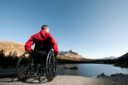 Person on manual wheelchair looking out over a lake