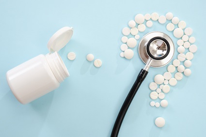 Pills and stethoscope on a light blue background