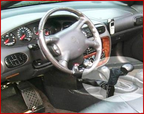 Photo shows that controls can be mounted for the left or right hand. Pictured here is a right-floor-mounted mechanical hand control. Also a removable accelerator pedal block and steering wheel spinner knob can be seen. Photo courtesy of Shepherd Center.