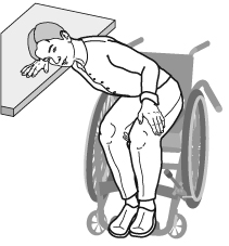 persona apoyada en silla de ruedas contra una mesa