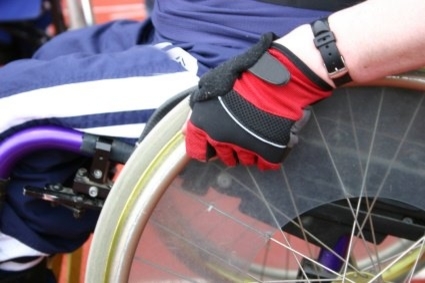 Man in wheelchair wearing red glove