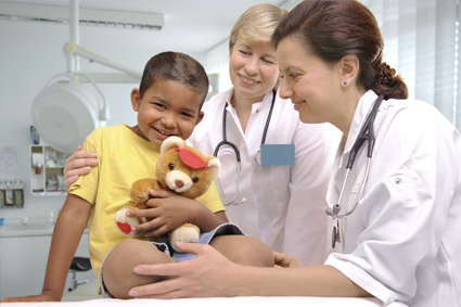Doctor giving teddy bear to child 