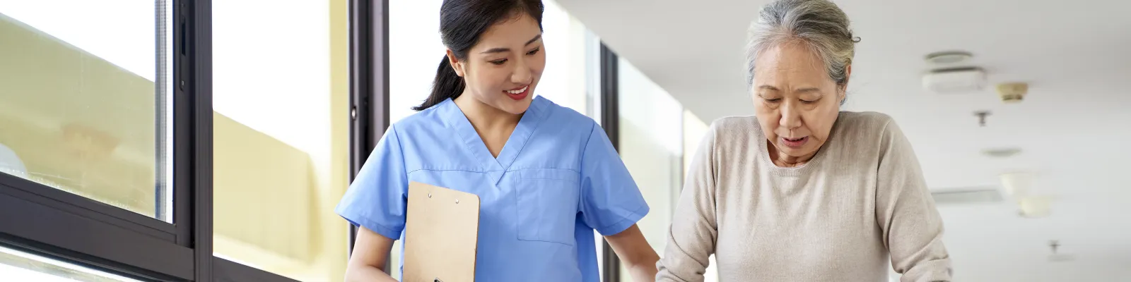 Health care working helping woman with walker walk