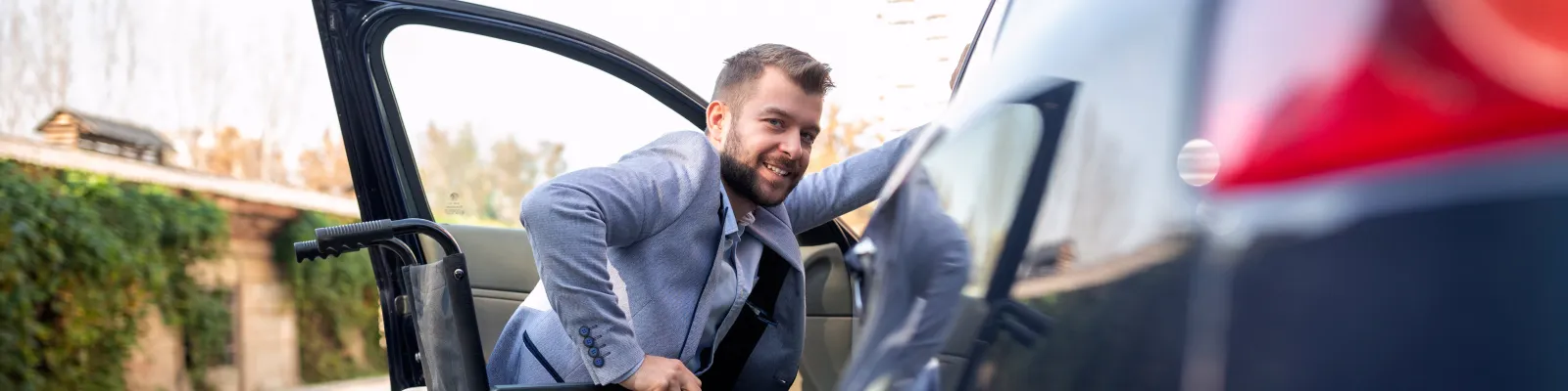 Photo of man transferring from wheelchair to vehicle