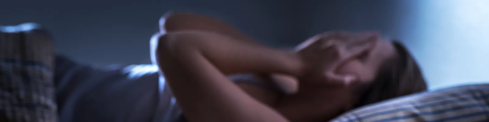 Photo of person awake in bed beside a clock that reads 3:41