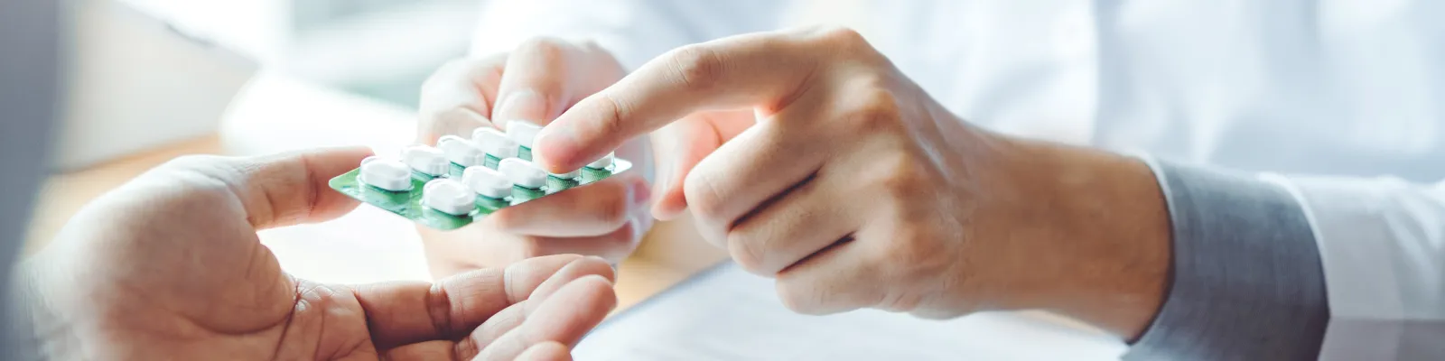 Photo of clinician handing a patient medication