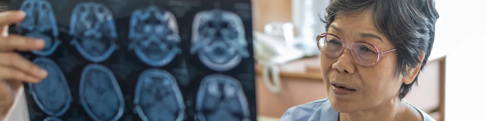 Photo of patient looking at brain scan films with clinician