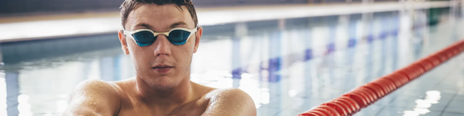 Photo of a young male with an amputated arm at a swimming pool