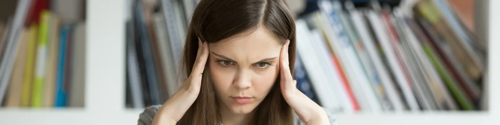 Photo of woman at computer holding her head