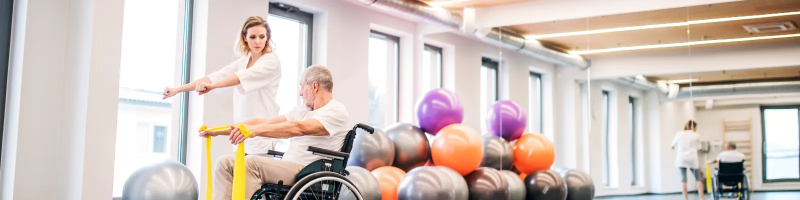 Photo of individual with SCI doing physical therapy with clinician