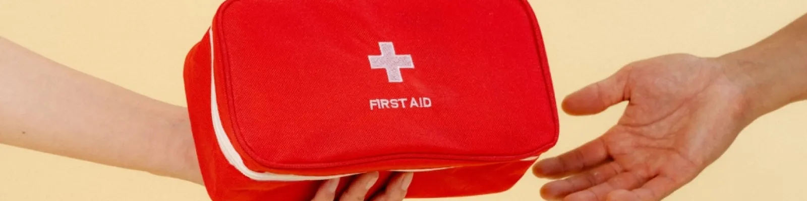 person handing someone a first aid kit