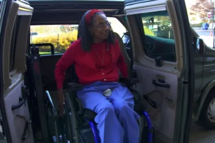 Older woman in a wheelchair exiting van