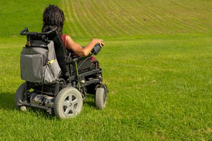 Woman on a wheelchair in a large field