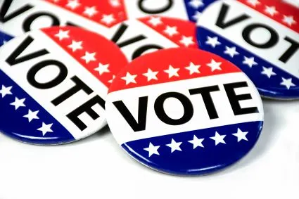 circular red and white buttons with stars drawn and "vote" written on it 