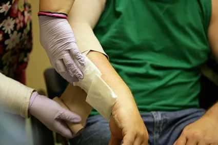 A caregiver dressing a burn on a patient's arm