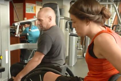 Man and woman with SCI working with gym equipment