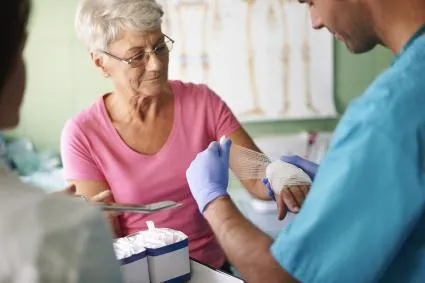Clinician dresses wound on woman's forearm