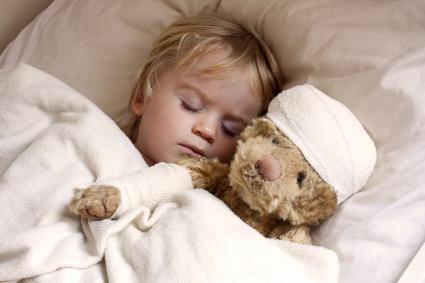 Child sleeping next to a teddy bear