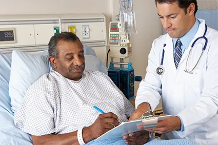 Man with Burn Injury in hospital bed, speaking with a clinician
