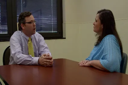 Clinician and patient talking across a table