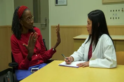 Woman in wheel chair talking to female doctor