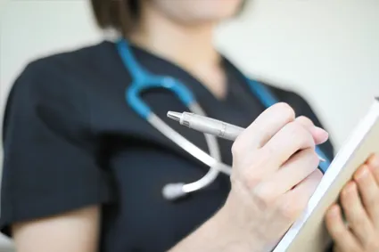 Clinician writing in a chart