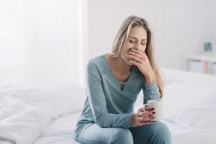 Woman covering yawn with her hand
