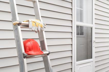 Ladder and hard hat leaning against a wall