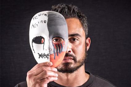 Man holding mask on half of his face