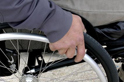 Person's hand on wheel of wheelchair