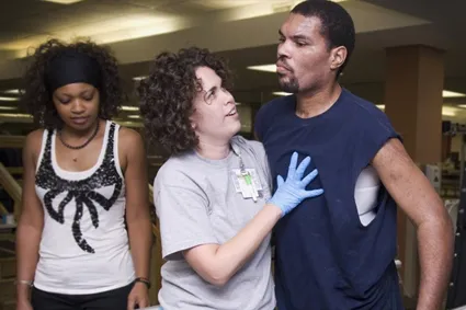 Female physical therapist helping male