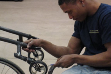 Man making repairs to manual wheelchair