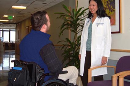 Man in wheelchair speaking with female doctor
