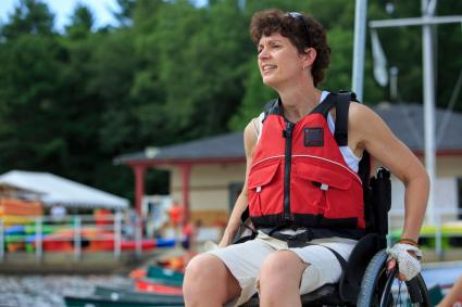 Photo of male in wheelchair wearing a lifejacket on a dock