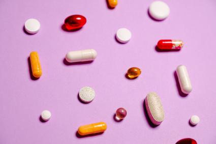Photo of multiple pills on purple background