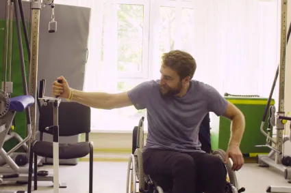 Photo of man in wheelchair exercising at home