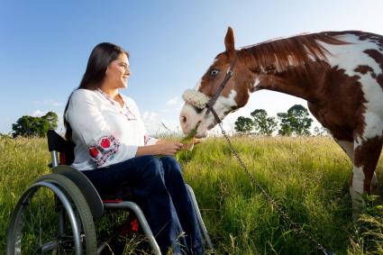 Photo of woman in wheelchair with a horse