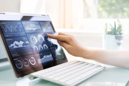 Photo of person's hand on a tablet with data on screen