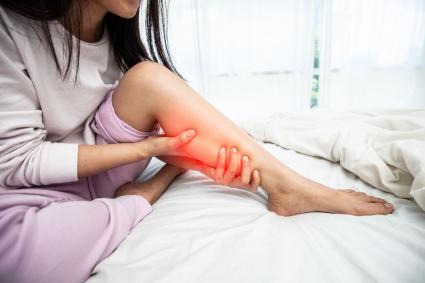 Photo of woman holding her leg in pain