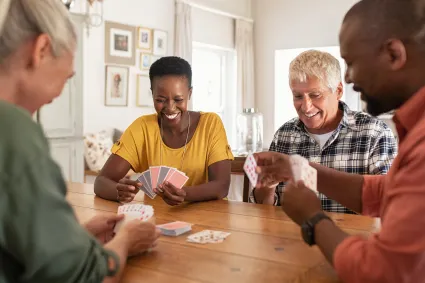 Photo of group of adults playing cards