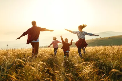 Photo of family running through field