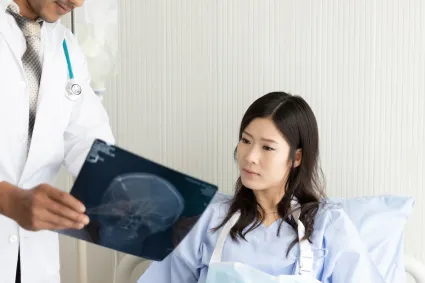 Photo of individual with TBI looking at brain imaging with clinician