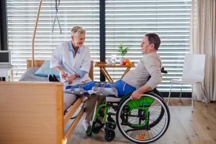 Photo of clinician working with the foot of a man in wheelchair 