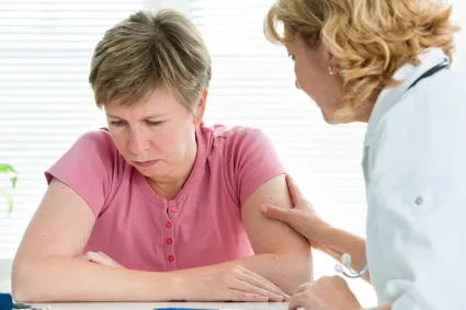 Photo of clinician helping woman who looks depressed