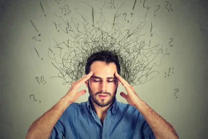 Photo of man holding his head