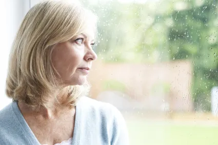 Photo of woman looking out of a window