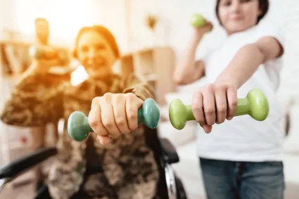 Photo of woman with SCI lifting a weight with a therapist