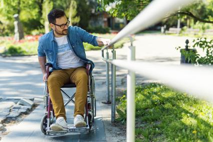 Photo of man in wheelchair going up a ramp