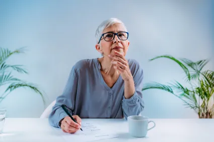 A woman thinking while writing